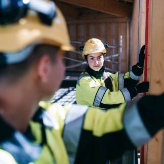 Opiskelijat asentamassa seinää