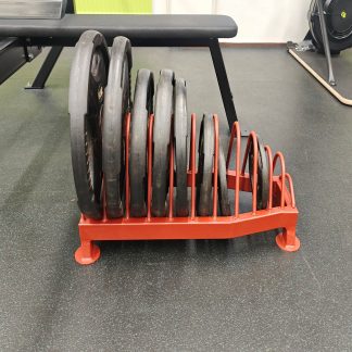 Punainen teline, jossa yksitoista eri väliä erikokoisille levypainoille.