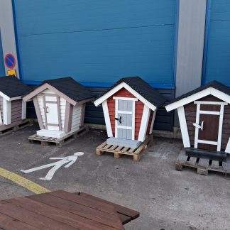 Neljä kappaletta pienoiskokoisia maitolaitureita. Vasemmalta lähtien; kahvin värinen, valkoinen, punainen ja ruskea. Maitolaitureissa on valkoiseksi maalatut kulmat.